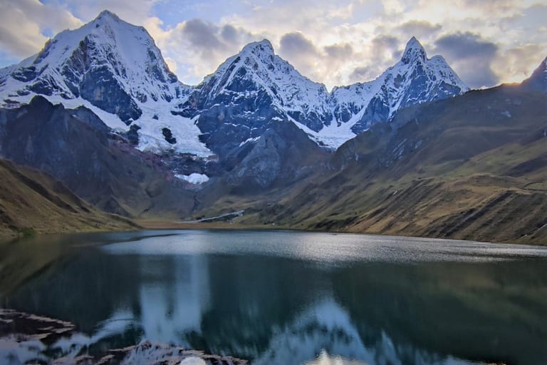 Laguna Carhuacocha Peru at first light, snow peaks of the Cordillera Huayhuash reflected in the still water